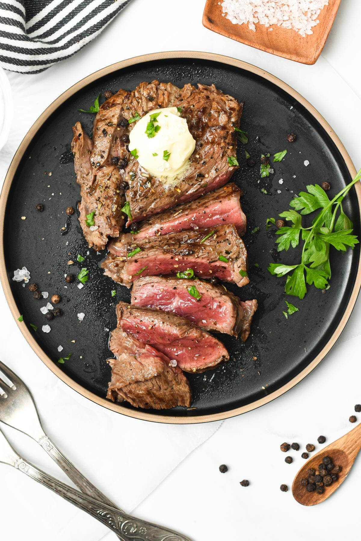 Meat marinated with 3 ingredient Steak Marinade on a black plate.