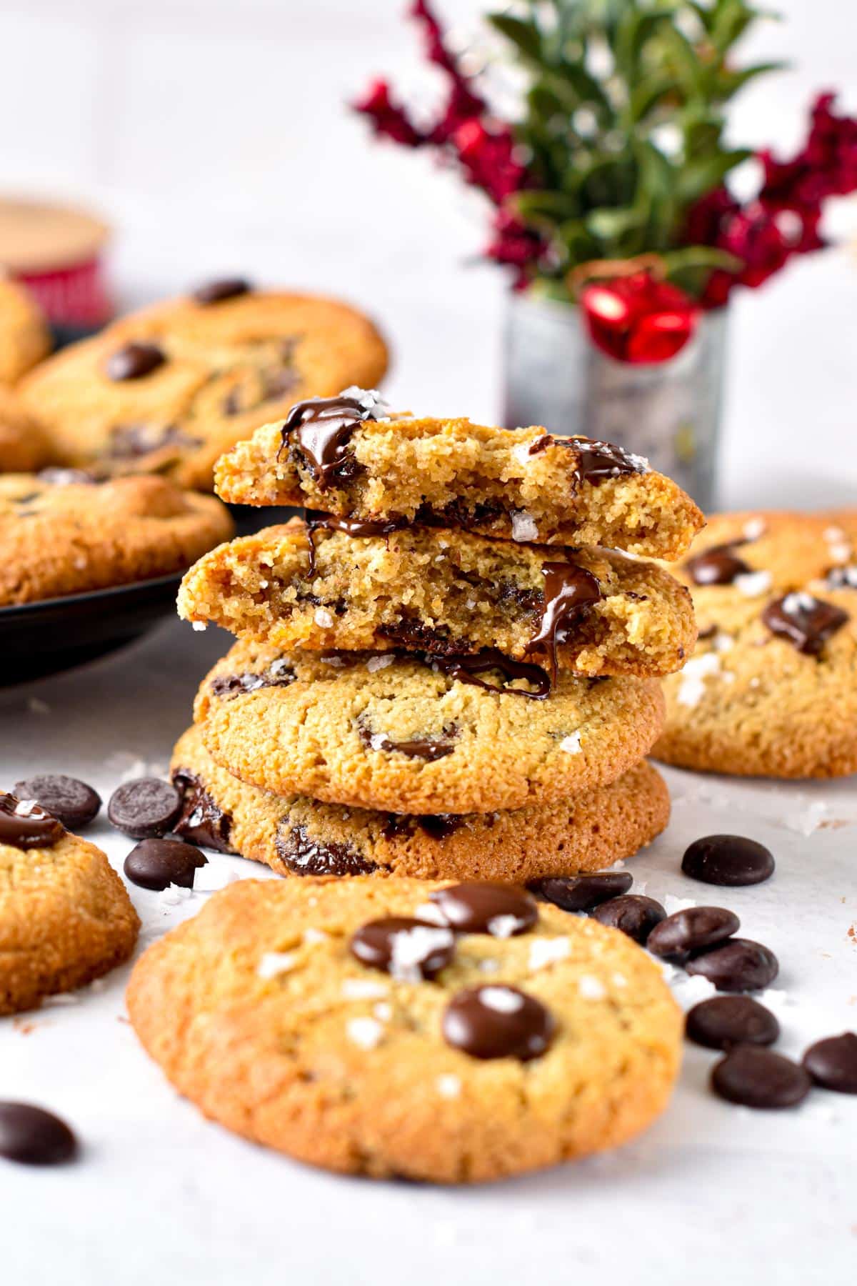 A stack of Almond Flour Chocolate Chip Cookies with two cookies split in half on top of the stack showing the cookie texture inside.
