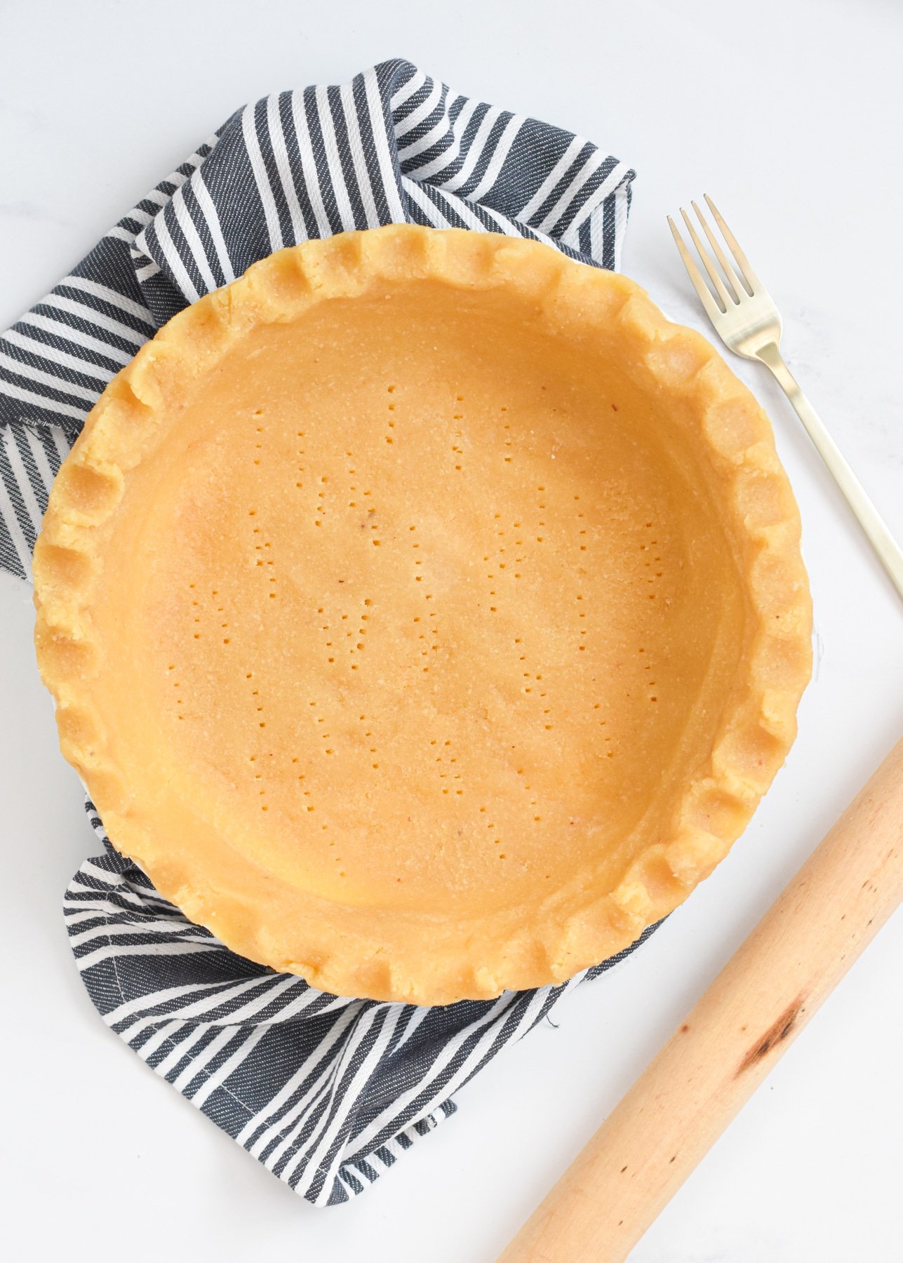 Almond Flour Pie Crust on a kitchen cloth next to a fork.