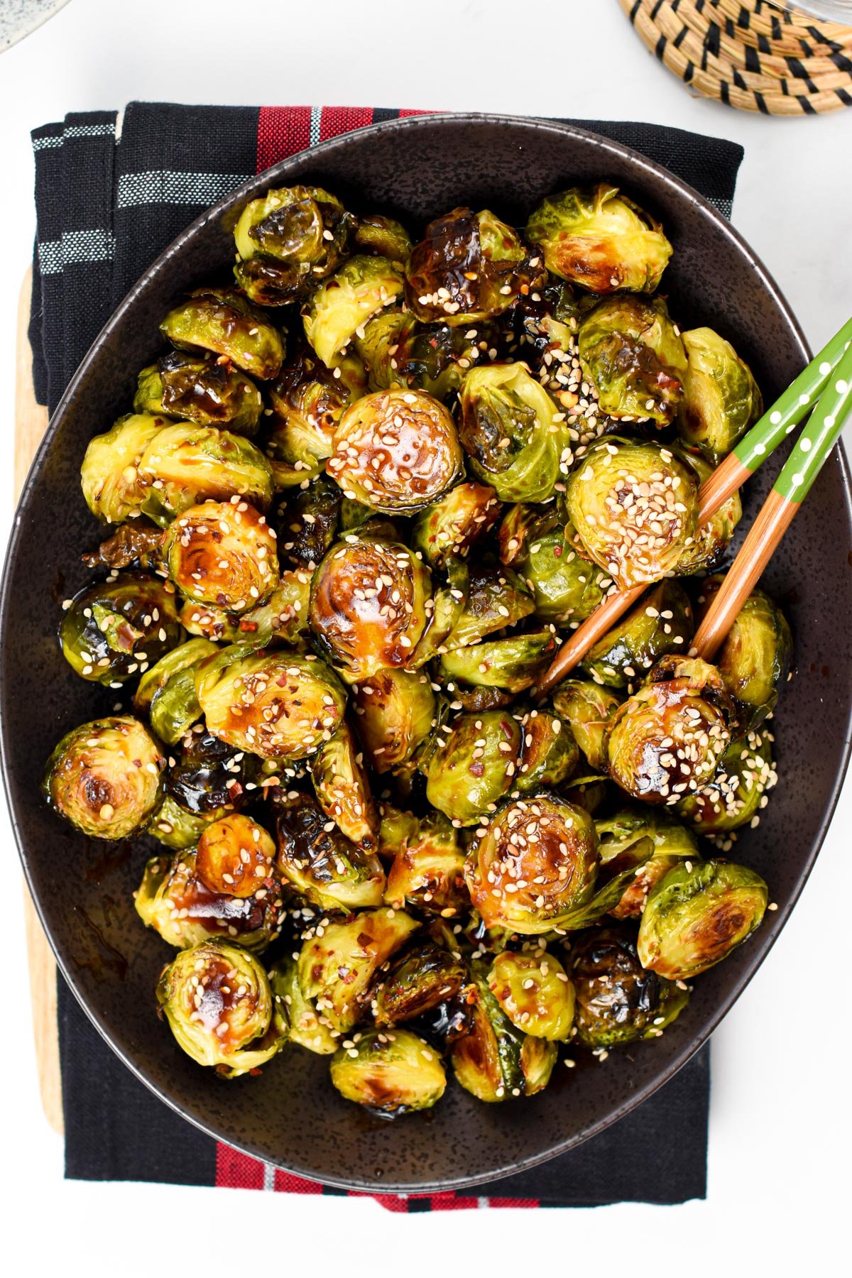 Asian Brussel Sprouts served on a large black plate.