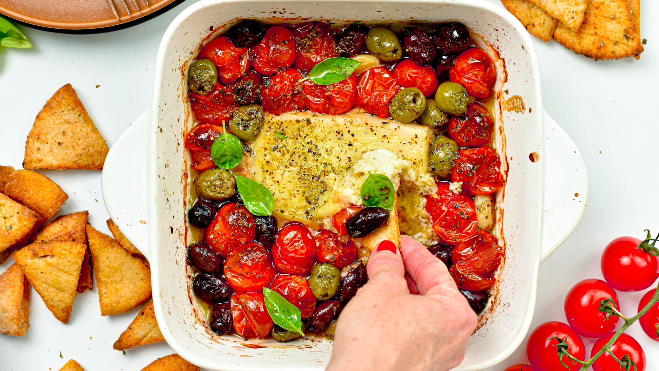 This Baked Feta Dip is a the most delicious hot dip with Meditareean flavors. A creamy cheese feta dip baked with olives, roasted cherry tomatoes and garlic.