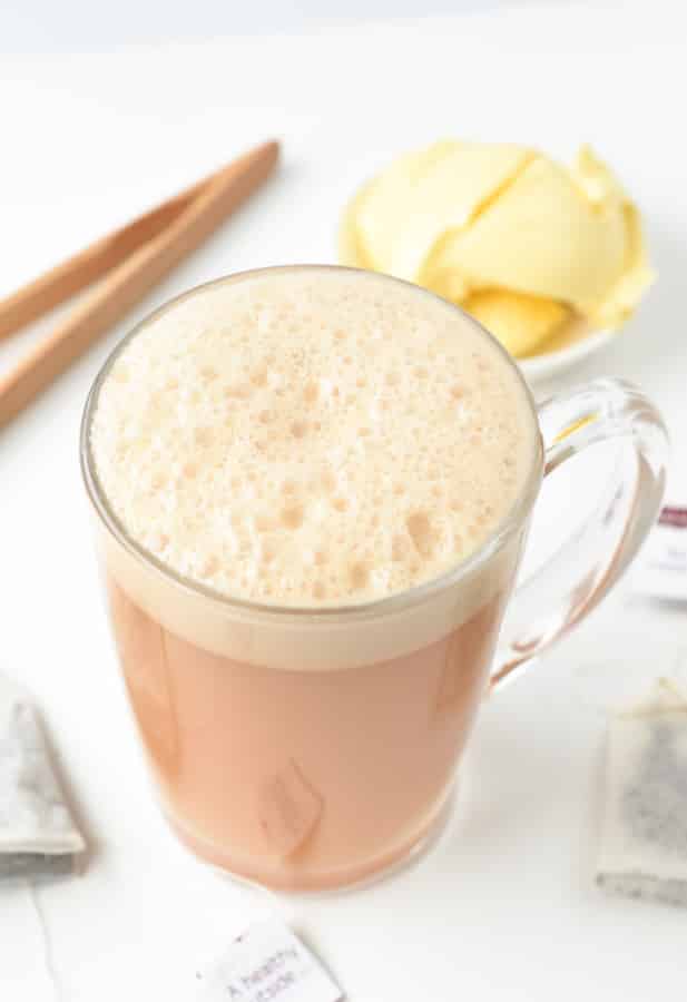 Bulletproof Tea Recipe in a small glass mug with butter in the background.