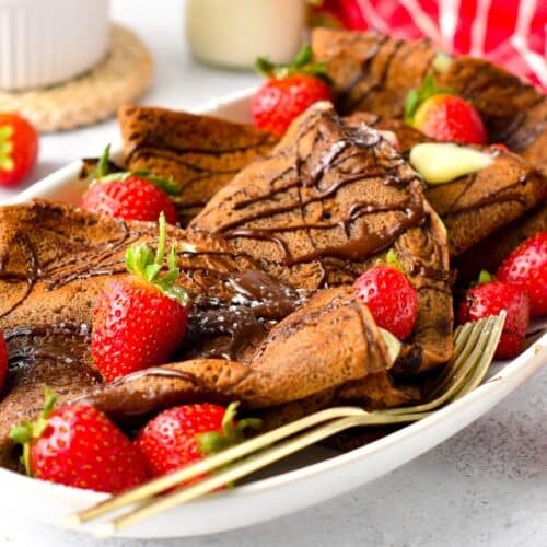 These Chocolate Crepes are thin chocolate French crepes perfect to fill with whipped cream, yogurt, or berries. It's an easy pancake recipe for breakfast or a delicious french dessert to impress.