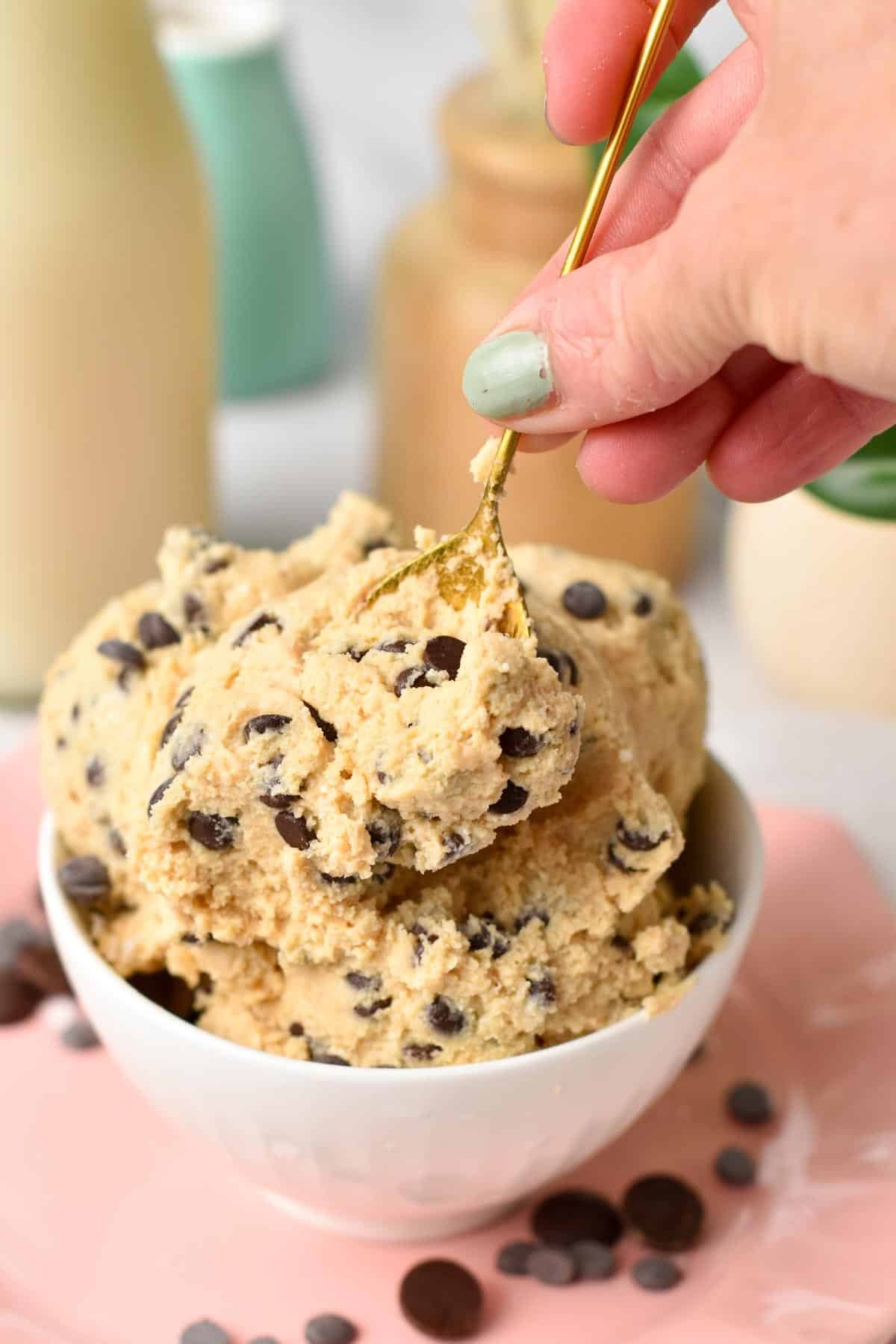 A golden spoon digging in a bowl filled with cottage cheese dough.