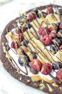 Healthy Paleo Brownie Fruit Pizza with almond meal, coconut flour and chia seed. Egg free, dairy free and gluten free. A fudgy chocolate dessert with delicious fresh toppings: coconut yogurt, peanut butter and fruits.