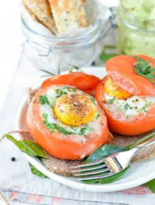 Low carb egg stuffed tomatoes with spinach and cheese. Delicious dinners or healthy breakfast recipes 100% gluten free and keto friendly.
