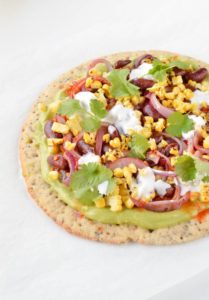 Skinny Avocado pizza with Mexican toppings and thin sprouted pizza base. An healthy pizza recipe ready in less than 15 minutes with delicious toppings: fried black beans, red onions, grilled corn, salsa sauce and coconut yogurt. Gluten free+ dairy free + skinny recipe.