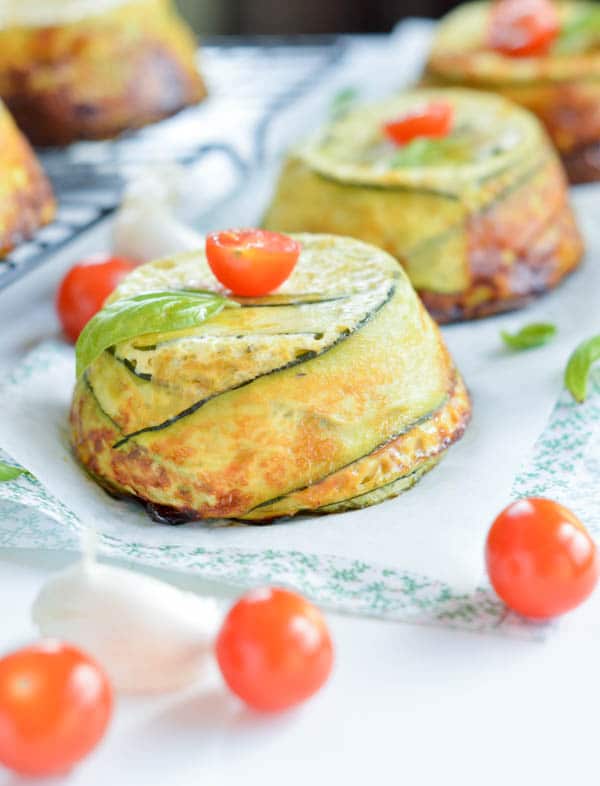 Single Serve CRUSTLESS ZUCCHINI QUICHE with Pesto and Parmesan. Low carb, 8.5g of net carbs per serve, fullfilling with 18.5g protein per serve. An healthy brunch recipe for the eggs lover. Clean eating quiche. Paleo + low carb. Muffin tin eggs recipe.