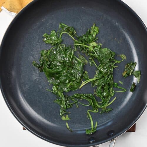 Wilted cooked spinach in a skillet