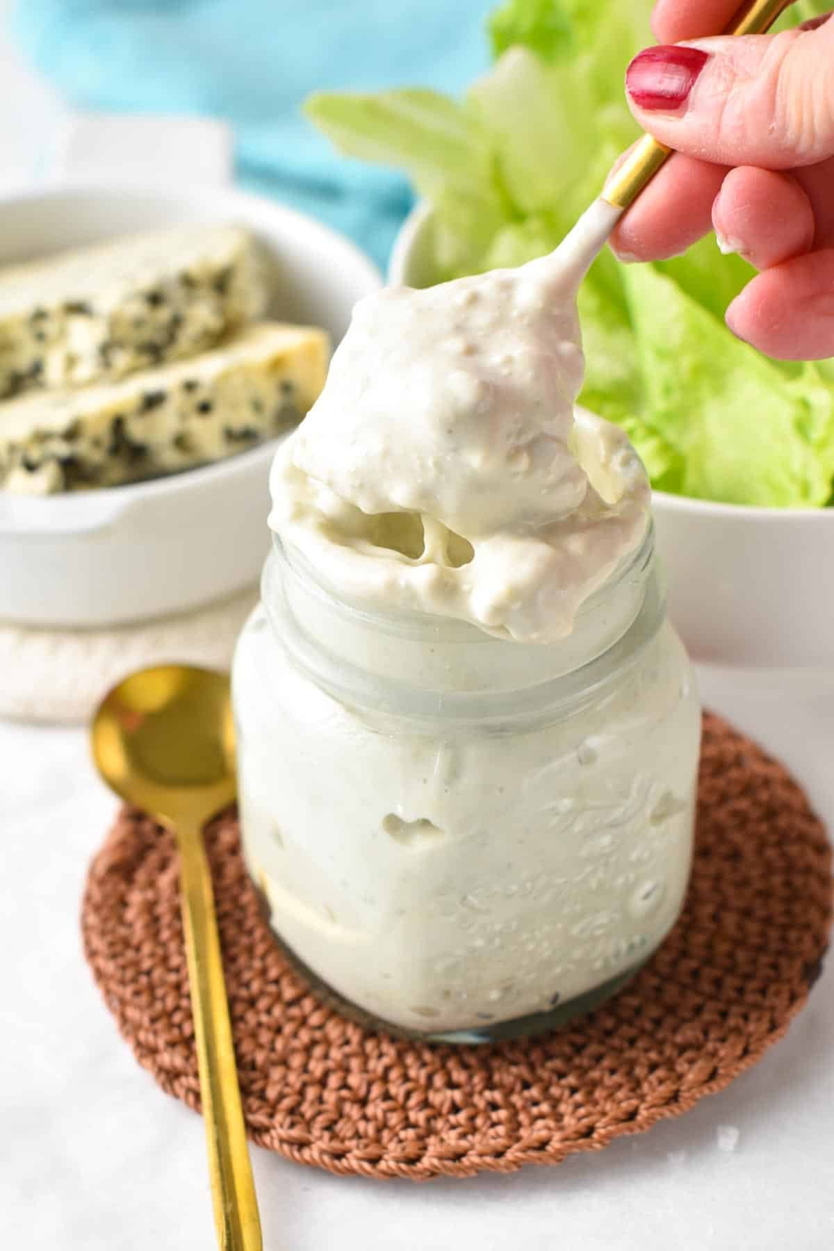 Golden spoon digging into a jar of  Gorgonzola Dressing.
