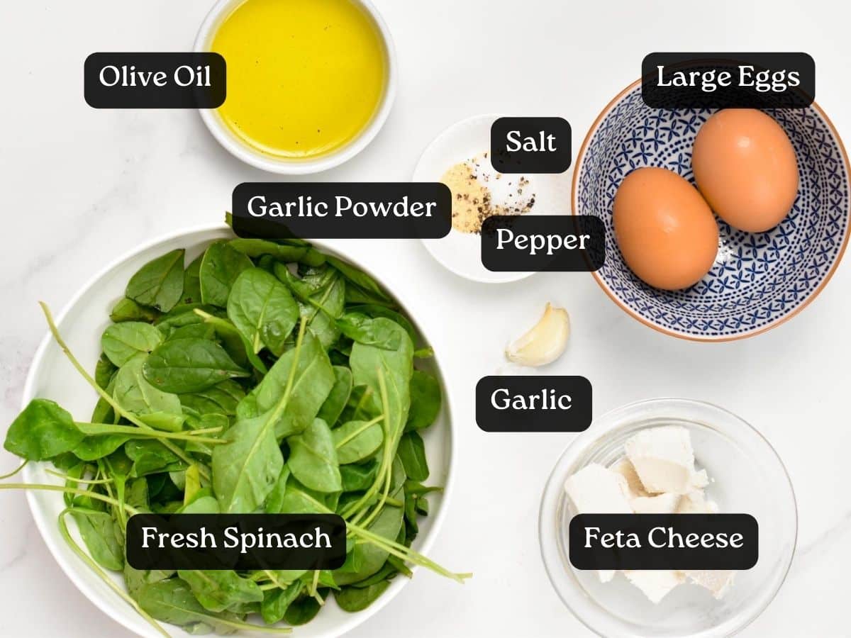 Ingredients for Feta Spinach Omelet : 2 eggs, a bowl with fresh baby spinach, olive oil, garlic, garlic powder, salt, pepper and feta cheese