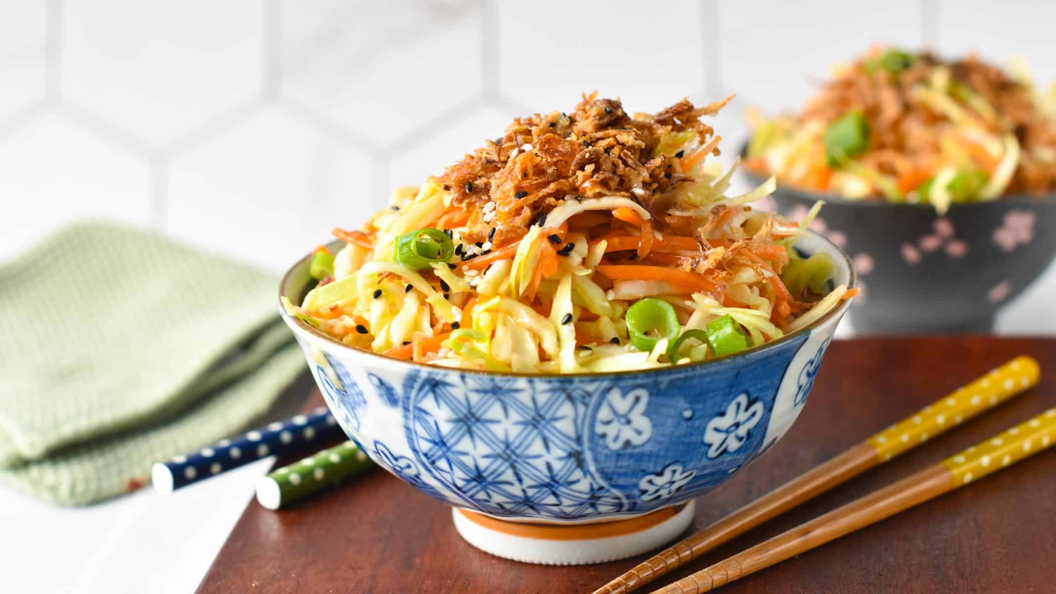 A bowl of Japanese cabbage salad topped with fried shallots.