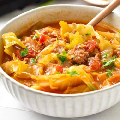 a bowl filled with low-carb cabbage soup made with green cabbage, beef broth, ground beef and celery and topped with fresh parsley