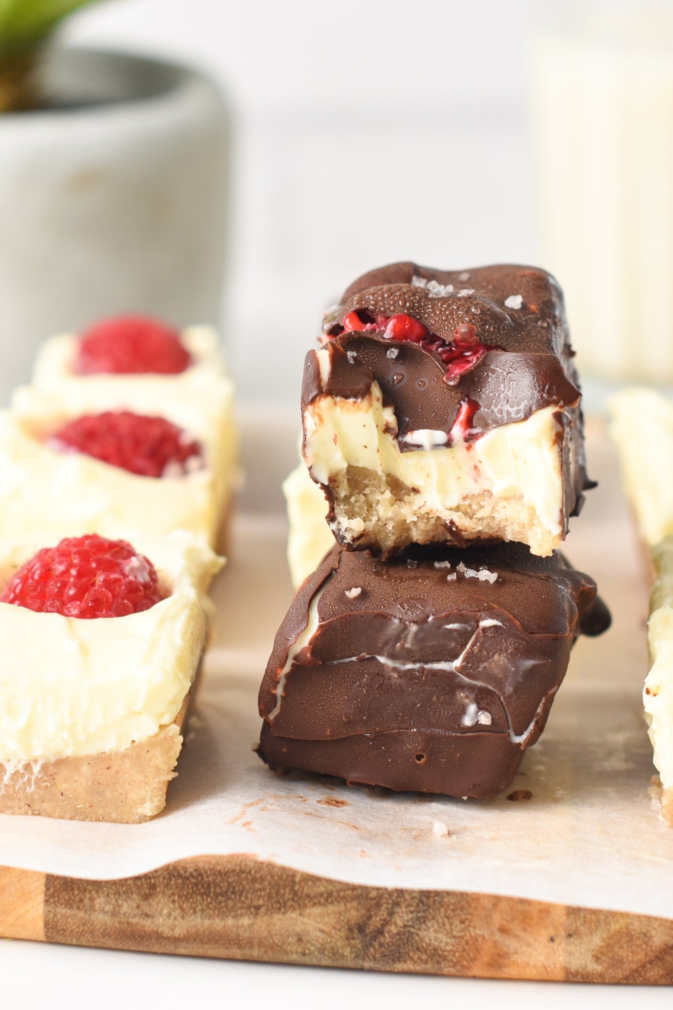 Keto Cheesecake Bites stacked on a wooden chopping board.