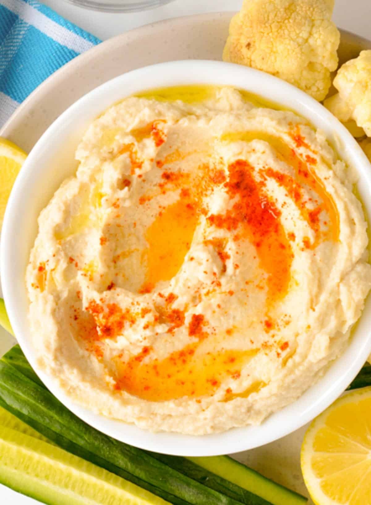 A bowl filled with keto hummus topped with olive oil and paprika.