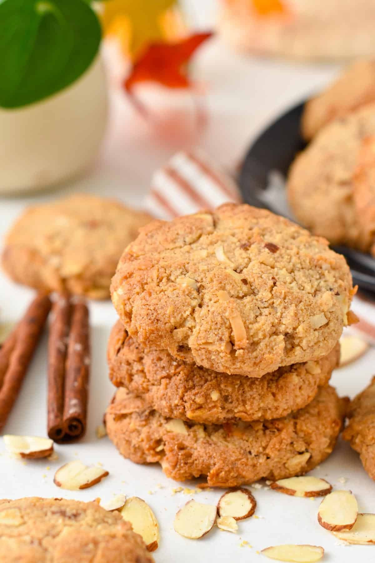 A stack of three keto oatmeal cookies made with cinnamon stick on sides and slices almonds.