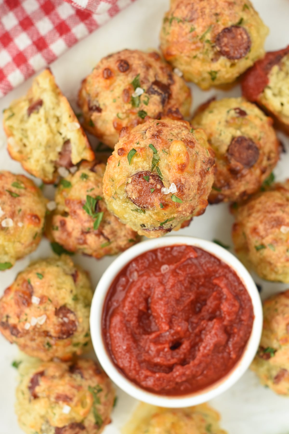 Keto Pizza Bites surrounding a small bowl with tomato sauce.