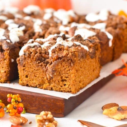 Slices of almond flour pumpkin cake topped with a pecan crumble and drizzle of yogurt