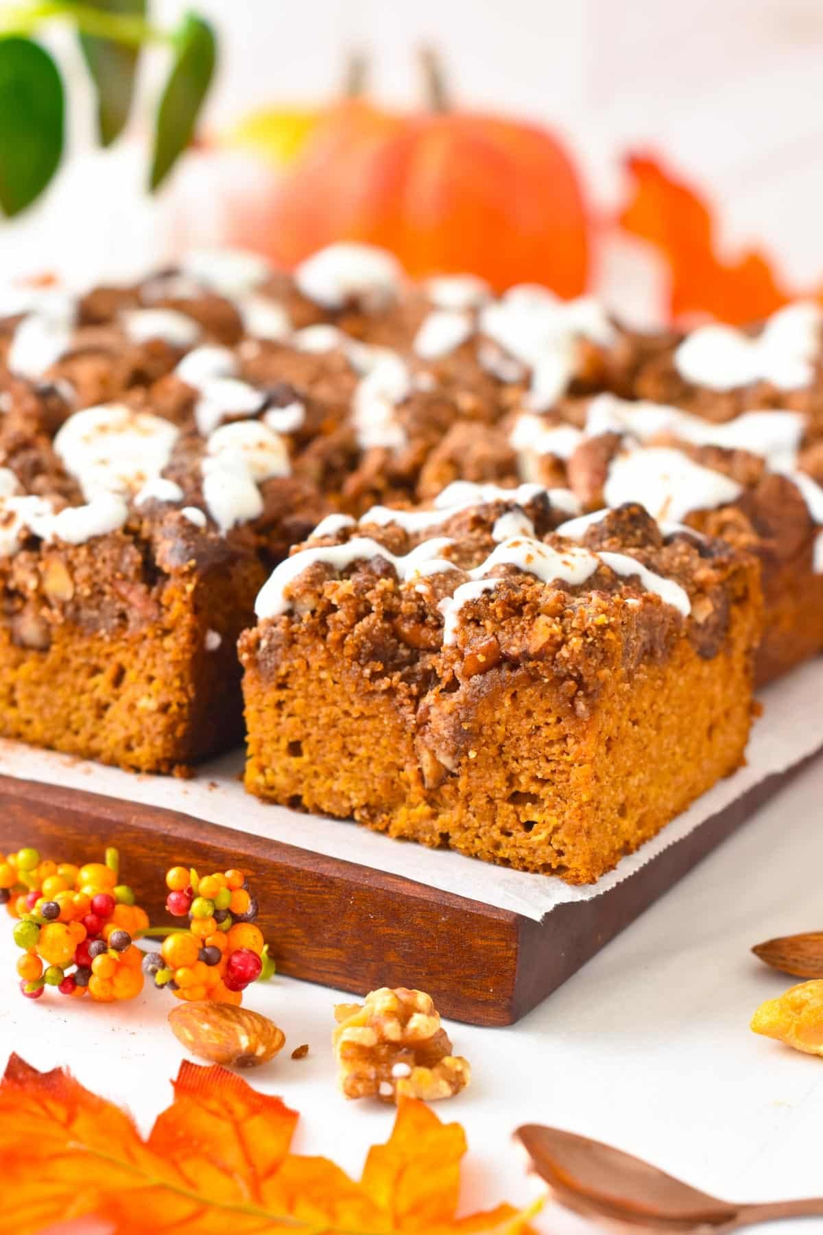 A slice of almond flour pumpkin cake topped with a pecan crumble and drizzle of yogurt.