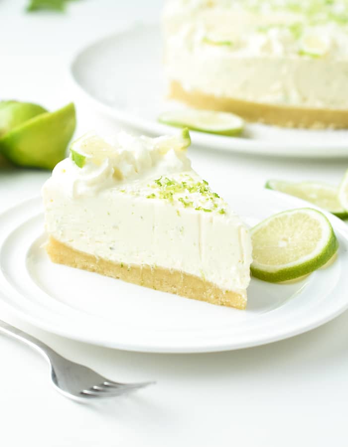 Keto key lime cheesecake on a white plate decorated with lime slices.