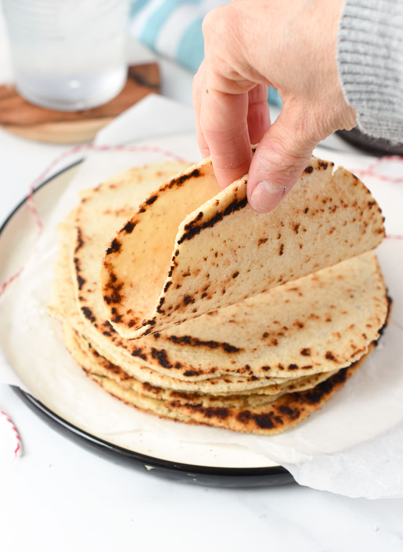 Holding a Low Carb Corn Tortilla in front of the stack of tortillas.