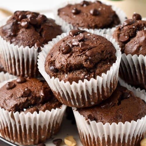 a chocolate protein muffins half bitten showing the fluffy texture and melted chocolate chips inside