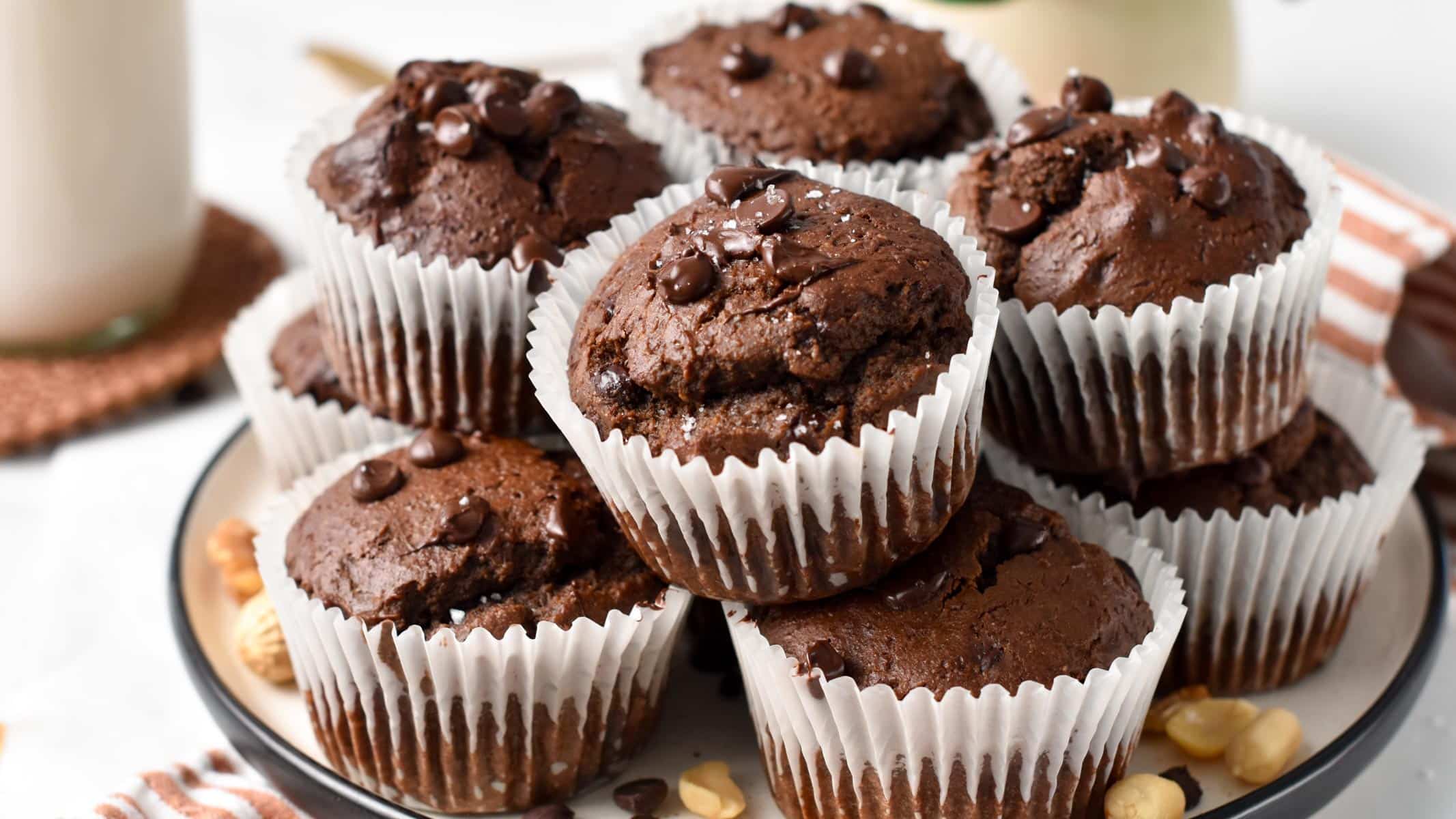 a chocolate protein muffins half bitten showing the fluffy texture and melted chocolate chips inside