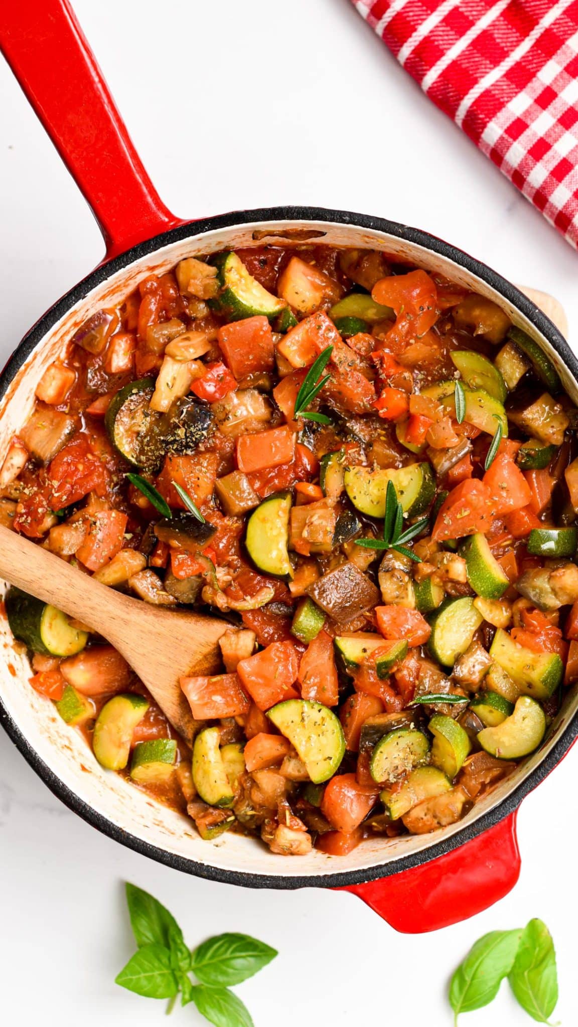 Ratatouille recipe in a large cast-iron Dutch oven with a wooden spoon.