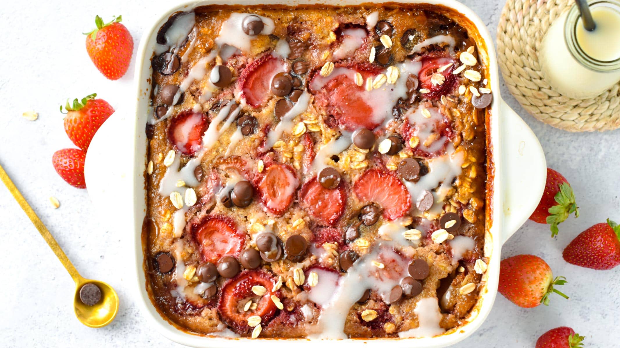 Strawberry Baked Oatmeal on a baking pan with a golden spoon.