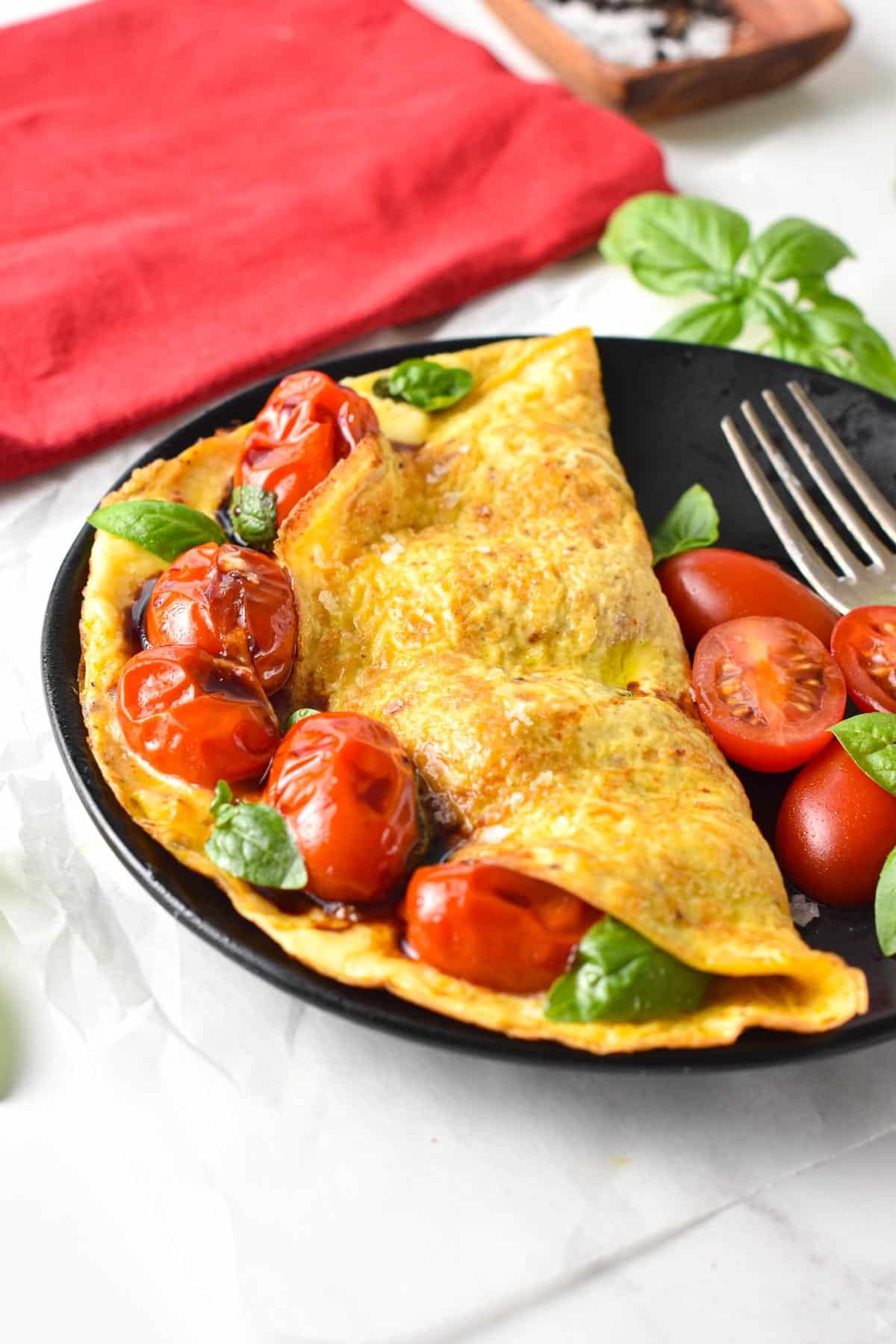 This Tomato Omelette is an easy, healthy breakfast recipe packed with summer flavors from juicy pan-fried cherry tomatoes, basil, and Parmesan cheese. If you love your eggs for breakfast, or you are looking for a fancy brunch, this omelette with tomato basil is a must-try.This Tomato Omelette is an easy, healthy breakfast recipe packed with summer flavors from juicy pan-fried cherry tomatoes, basil, and Parmesan cheese. If you love your eggs for breakfast, or you are looking for a fancy brunch, this omelette with tomato basil is a must-try.