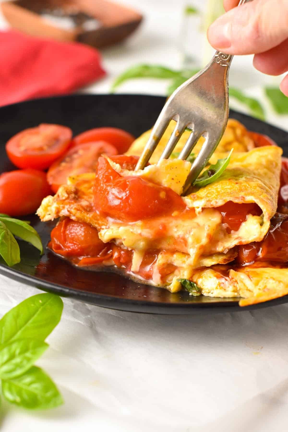This Tomato Omelette is an easy, healthy breakfast recipe packed with summer flavors from juicy pan-fried cherry tomatoes, basil, and Parmesan cheese. If you love your eggs for breakfast, or you are looking for a fancy brunch, this omelette with tomato basil is a must-try.