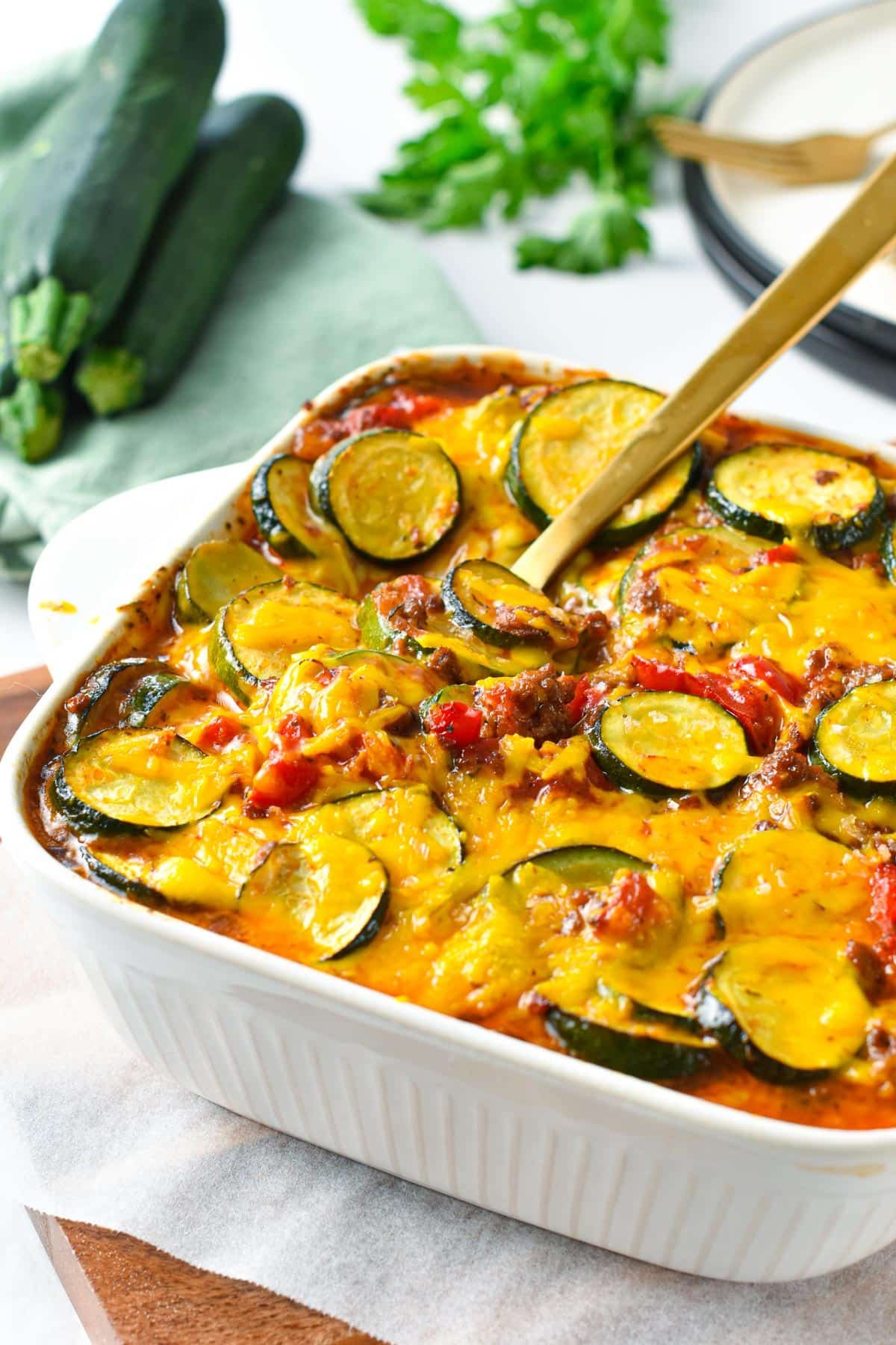This Zucchini Sausage Casserole is an easy and healthy family dinner to use for your summer zucchini. Delicious crunchy zucchini slices, cooked in a homemade tomato sauce with tasty pieces of ground sausage.